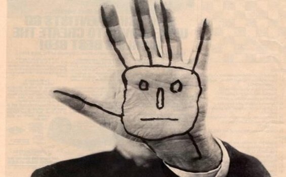 Ausgestreckte Hand mit aufgemaltem Gesicht