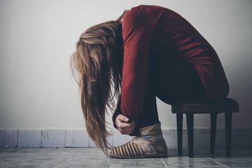 Verzweifelte Frau beugt sich über ihre Knie