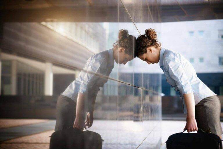 Erschöpfte Frau lehnt sich an Wand