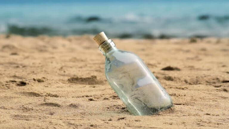 Glasflasche steckt im Sand