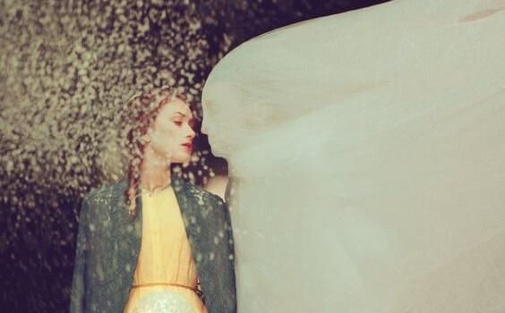 Frau wird von Mann in weißem Gewand geküsst