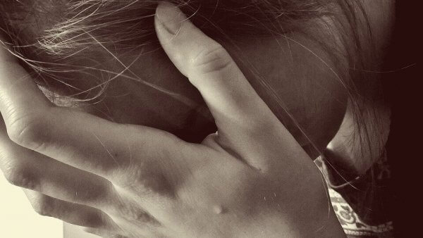 Frau stützt ihren Kopf in ihre Hände