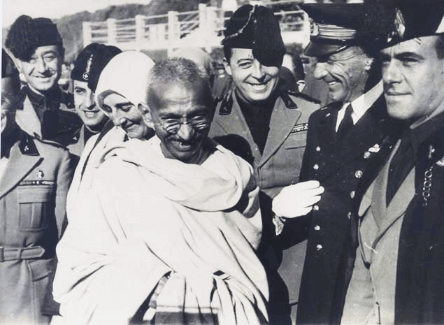 Gandhi umgeben von Menschen in Uniform