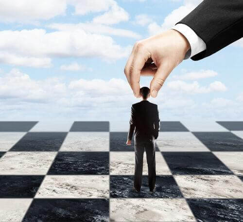 Mann wird auf einem Schachbrett von jemand anderem geführt