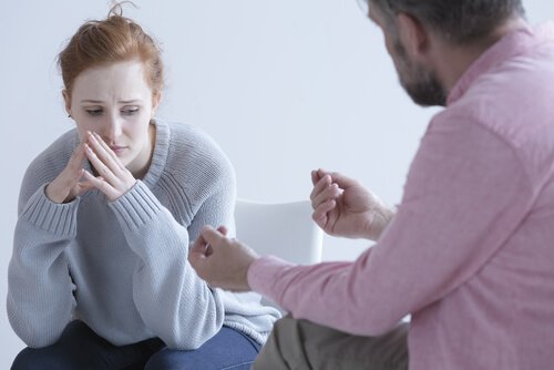 Eine nachdenkliche Frau hört einem Mann zu