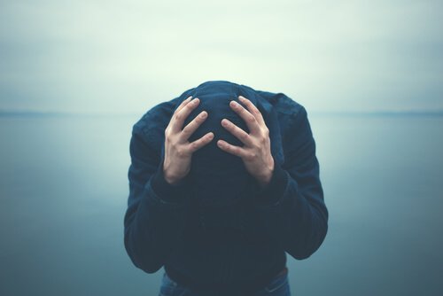 Mann hält seinen Kopf mit beiden Händen