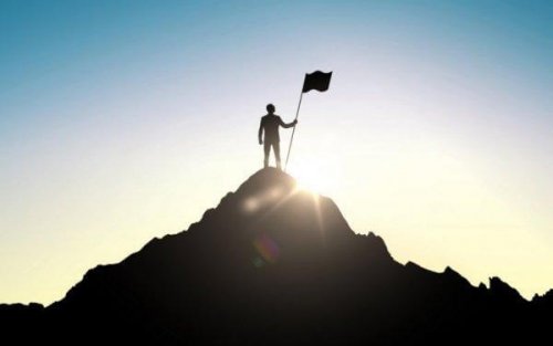 Mann, der auf einer Bergspitze steht