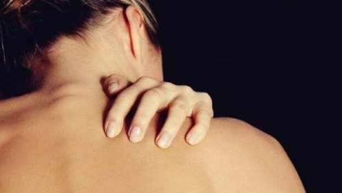 Frau berührt die Haut ihrer Schulter