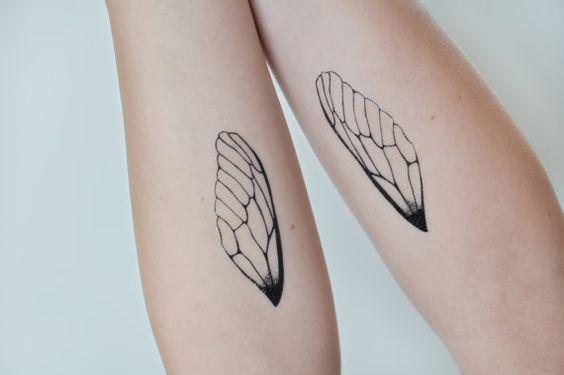 Zwei Arme mit je einem Flügeltattoo als Zeichen von emotionaler Unabhängigkeit
