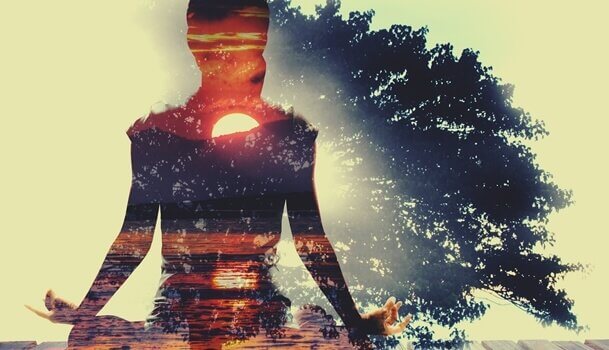 Frau meditiert vor Sonnenuntergang