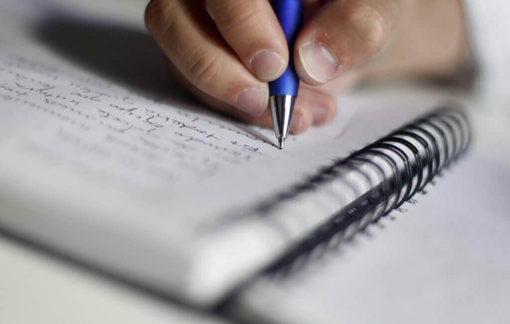 Jemand schreibt etwas auf einen Block