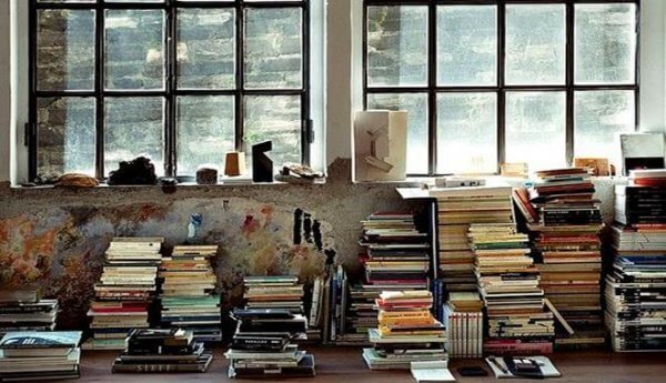 Aufgestapelte Bücher vor einem Fenster