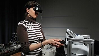 Eine Frau mit verbundenen Augen bedient einen Roboter.