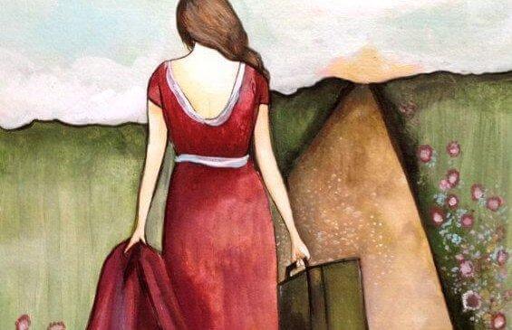 Frau läuft mit Koffer einen Weg entlang