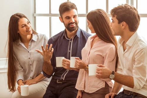Vier Freunde trinken zusammen Kaffee und plaudern