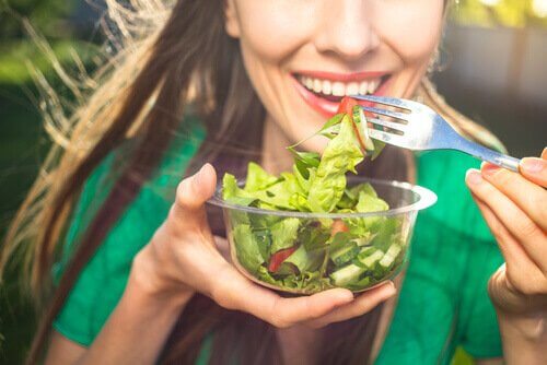 Eine Frau isst einen Salat.