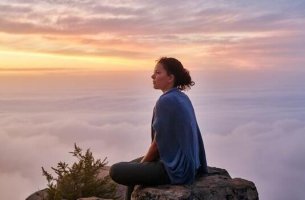 Pablo Neruda und die Stille - Frau meditiert über den Wolken