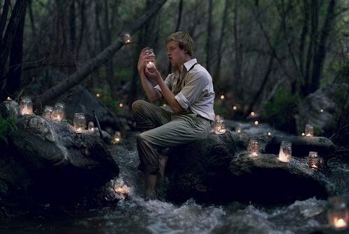 Mann mit Kerzen im Fluss