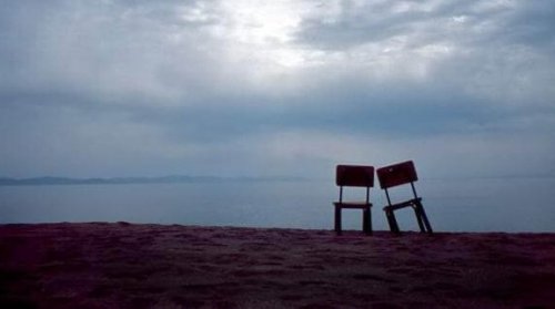 Zwei Stühle stehen vor dem Meer