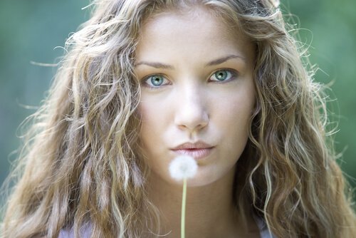 Eine Frau hält eine Pusteblume