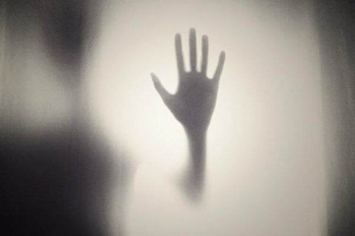 Hand, die an ein Fenster lehnt