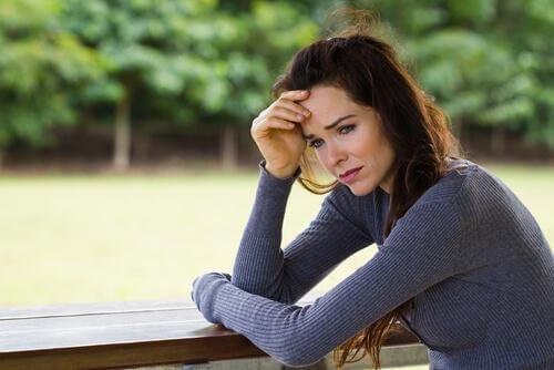 Verzweifelte Frau am Tisch im Park