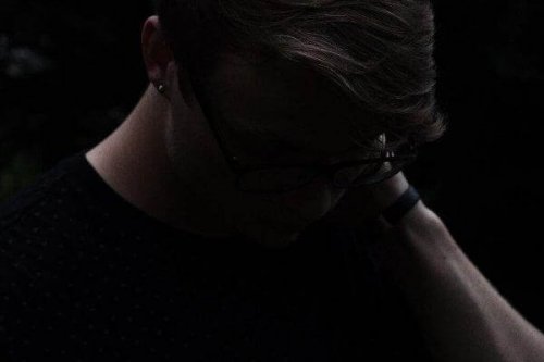 Dunkles Bild einer zu Boden blickenden Person