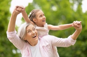Eine Oma spielt mit Ihrer Enkeltochter im Grünen