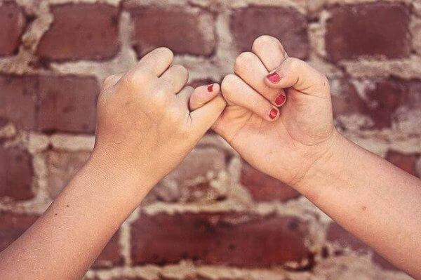 Zwei Hände, am kleinen Finger eingehakt.
