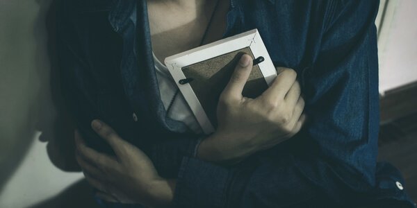 Frau hält ein Foto im Arm