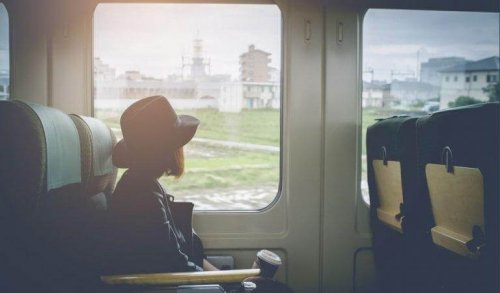 Frau sitzt im Zug und starrt aus dem Fenster
