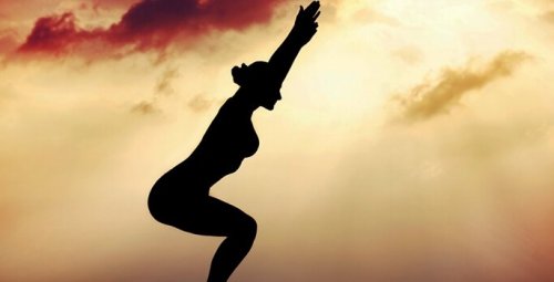 Frau kennt die Gründe, Tai Chi zu machen und führt eine Stellung mit ausgestreckten Armen aus