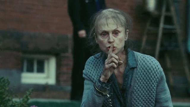 Frau hält sich ihren Finger vor den Mund, um etwas zu verheimlichen