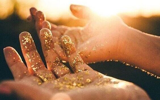 Hände mit goldenem Puder