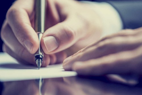 Eine Hand schreibt etwas mit einem Füller
