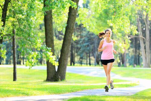 Lachende Frau joggt im Park