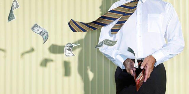 Ein Mann öffnet seine Brieftasche und es fliegen Geldscheine heraus.