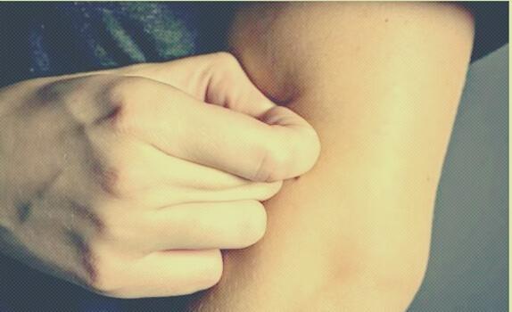 Mann kneift seine Haut