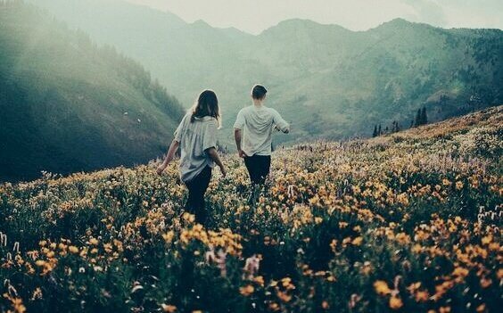 Paar geht auf einer Blumenwiese
