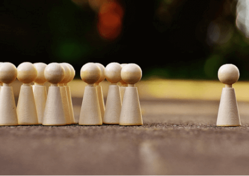 Eine Figur steht einer Gruppe von Figuren gegenüber