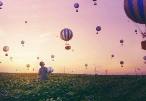 Mann in einem Feld unter zahlreichen Heißluftballons