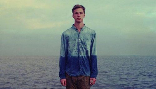 Junger Mann am und im Wasser