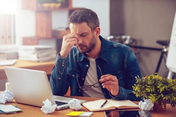 Ein Mann am Laptop erfährt die Auswirkung von Stress.