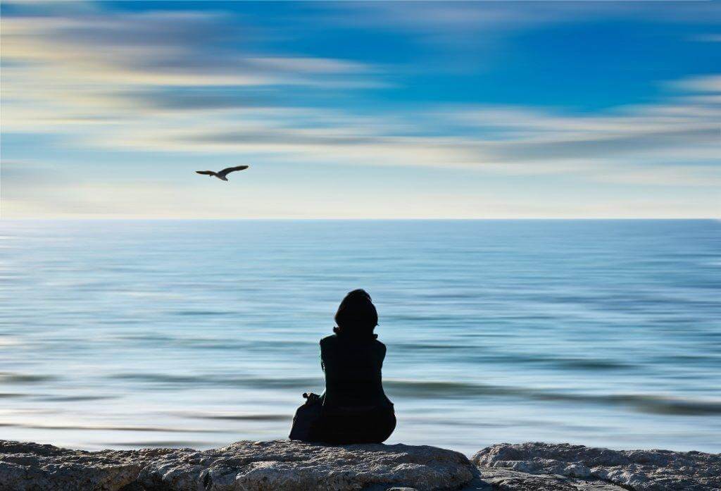 Frau schaut aufs Meer