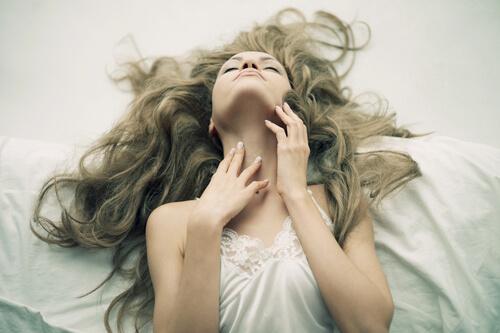 Frau beim Orgasmus im Bett