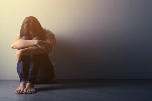 Frau mit endogener Depression sitzt am Boden