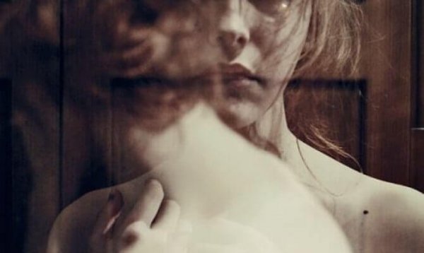 Eine verstörte Frau erscheint im Spiegel.