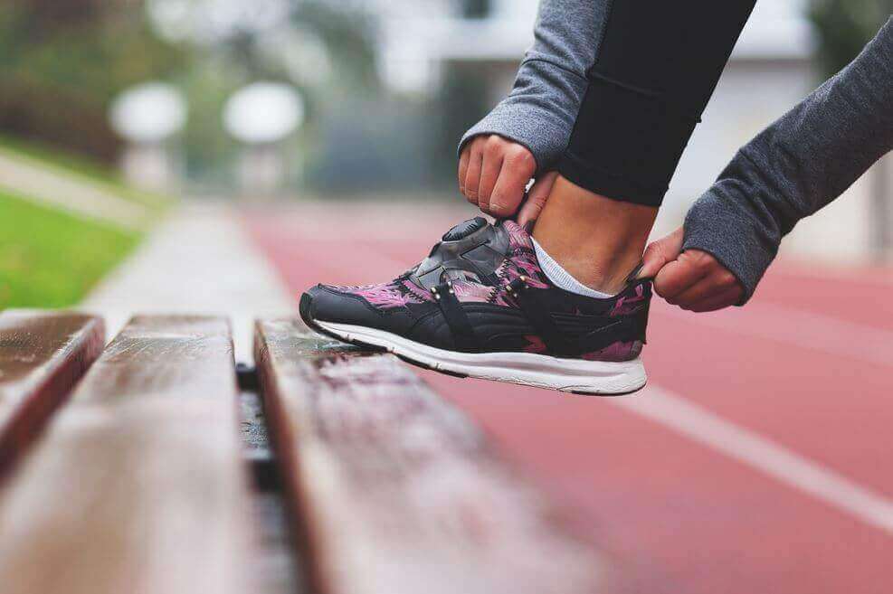 Frau zieht sich einen Laufschuh an