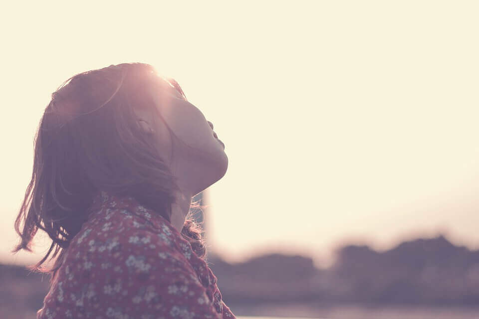 Mädchen sitzt allein in der Sonne