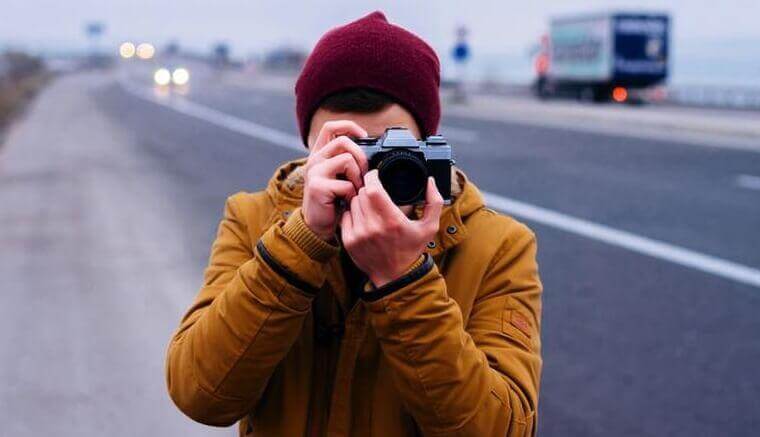 Mann mit Kamera macht ein Foto